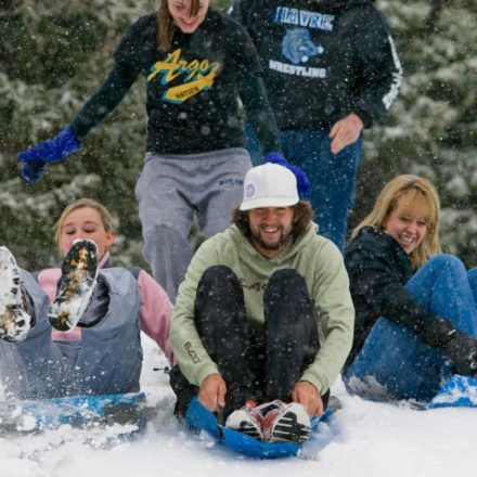 Students sledding down a hill