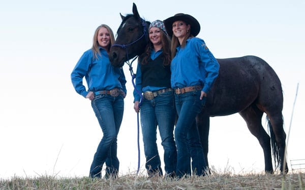 Female students standing with a horse